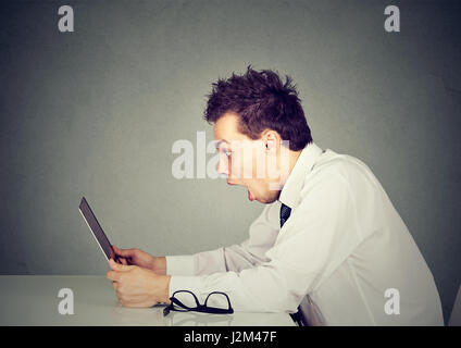 Choqué surpris man looking at laptop computer étonné et surpris avec la bouche ouverte et de grands yeux. Banque D'Images