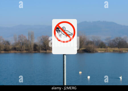 Ne pas nourrir les canards signer près du lac avec une pataugeoire d'oies et de montagne dans l'arrière-plan Banque D'Images