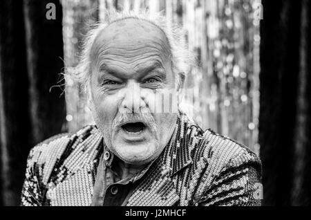 Vieil homme furieux en criant à l'appareil photo avec une expression de colère et baleful stare dans la tête et des épaules la tonalité de gris Banque D'Images