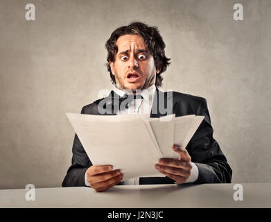 Accablé man holding papers Banque D'Images