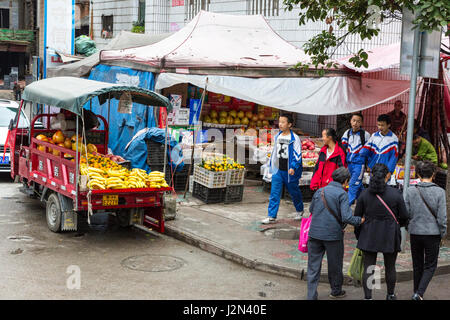 Kaili, Guizhou, en Chine. Stand de fruits sur un coin de rue du centre-ville. Banque D'Images