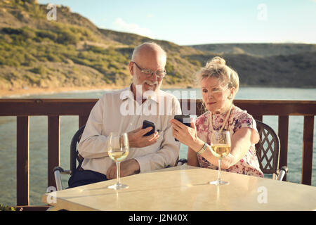 Vieux couple regardant leurs téléphones portables Banque D'Images