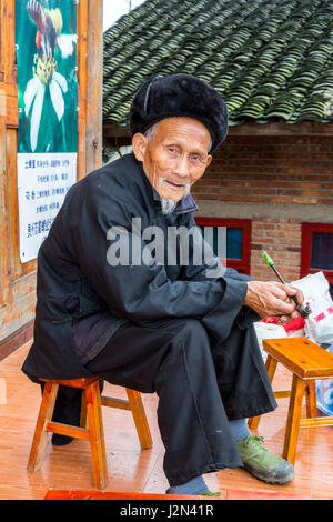 Matang, Village Gejia du Guizhou, en Chine. Vieil Homme avec sa pipe. Banque D'Images