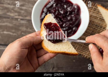 Préparer le petit-déjeuner de confiture de cerise sur toast Banque D'Images