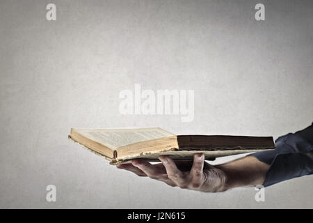 Livre ouvert dans la main de quelqu'un Banque D'Images