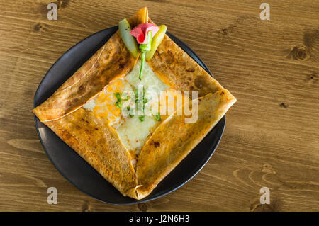 Vue de dessus avec le fromage cheddar crêpe délicieuse servie sur une plaque gris sur une table en bois Banque D'Images