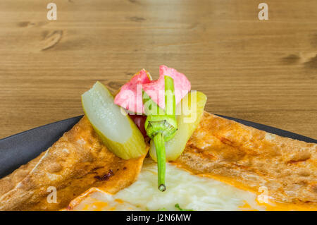 Gros plan du délicieux fromage cheddar avec crêpe servie sur une plaque gris sur une table en bois Banque D'Images