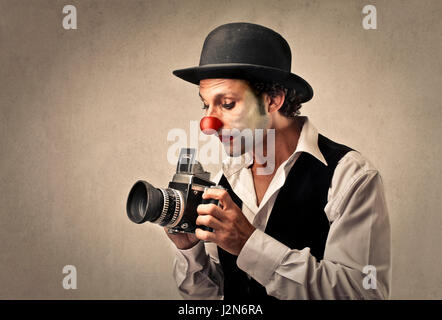 Homme clown avec appareil photo professionnel Banque D'Images