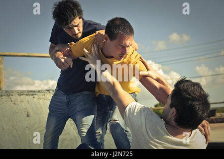 3 hommes qui combattaient l'extérieur Banque D'Images