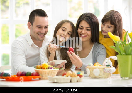 Jeune famille heureux ensemble sur la préparation d'oeufs de Pâques Banque D'Images