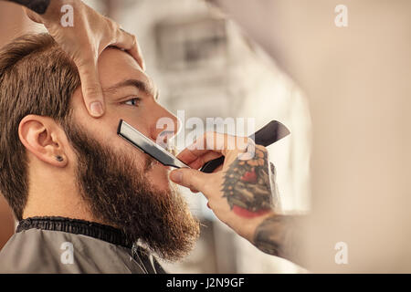 Salon de coiffure avec vieux barbu de rasage rasoir noir Banque D'Images