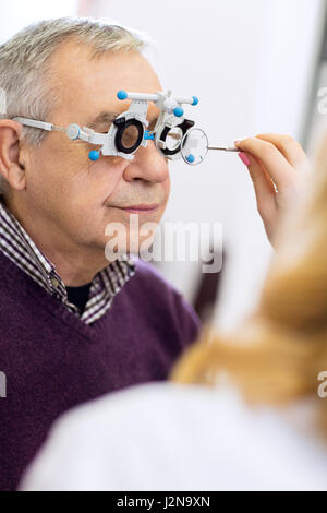 Médecin ophtalmologie mesurer la distance d'yeux élève en salle de consultation Banque D'Images