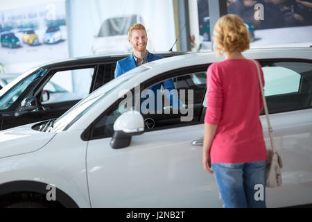 Dealer montrant un nouveau modèle de voiture à l'acheteur potentiel Banque D'Images