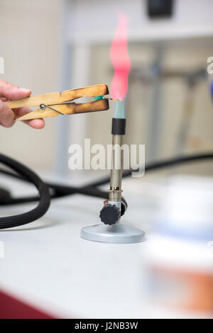 Vue rapprochée de brûleur de laboratoire et des pinces aiguille holding in chemistry lab Banque D'Images