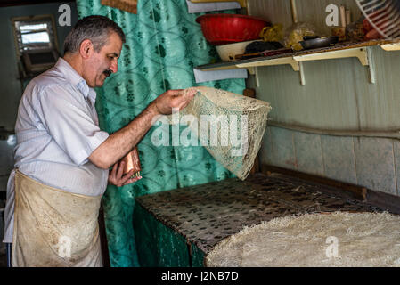 Rustam Hasanov, baklava un maître, prépare la pâte à sa cuisine et shop en même temps à Quba, Azerbaïdjan. Banque D'Images