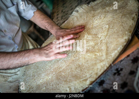 Rustam Hasanov, baklava un maître, prépare la pâte à sa cuisine et shop en même temps à Quba, Azerbaïdjan. Banque D'Images