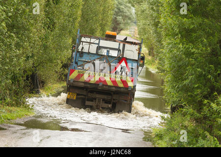 16 juillet 2012 - Les véhicules roulant dans l'inondation sur les niveaux de Somerset sur la route entre Glastonbury et Godney Banque D'Images