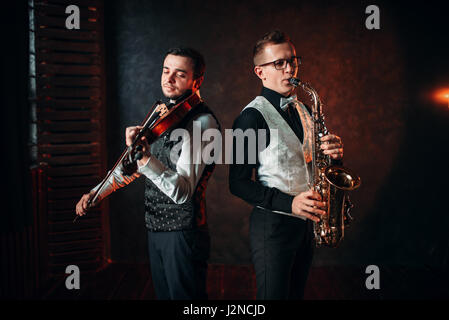 Le saxophoniste et violinst jouant la mélodie classique, duo musical. Jazz-man et fiddler Banque D'Images