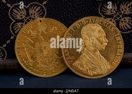 Vue rapprochée de deux l'une sur l'autre l'Autriche-Hongrie thalers, avers et revers de médaille d'or de 1915 ducats-Kaiser Franz Joseph I avec Banque D'Images