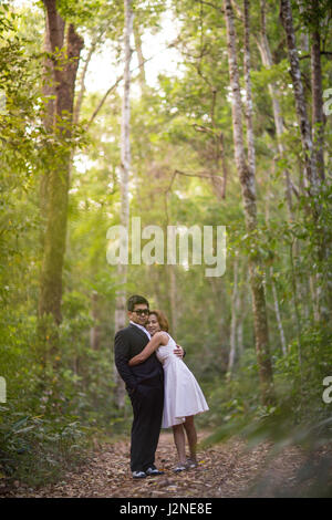 Un couple en tenue habillée robe blanche et costume noir romance dans la forêt de pins avant mariage, Thaïlande Banque D'Images