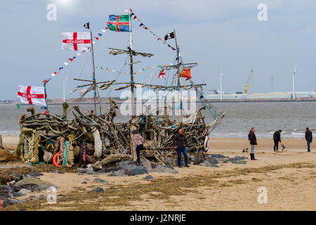 Bateau pirate lever du soleil sur la rivière Mersey, centre-ville, sculpture en bois, quais et port. Le Black Pearl est une œuvre interactive en bois flotté, créée et entretenue par un petit groupe de pirates passionnés sur la rive de New Brighton. Une réplique d'un homme de guerre pirate à trois mâts, il est presque entièrement construit à partir de matériaux récupérés, de la ferraille, des déchets, de l'élimination, de la substance, Épave, équipement, matière première, œuvres d'art en bois flotté sur la plage de Liverpool Merseyside. Banque D'Images