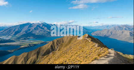 Sur les montagnes et le lac, femme sautant en haut ridge, Roys Peak, Lake Wanaka, Alpes du Sud, région de l'Otago, Southland Banque D'Images