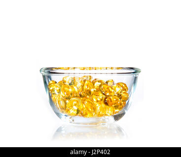 Sacha Inchi jaune vif soft gel pills dans un bol en verre clair sur fond blanc avec copie espace Banque D'Images