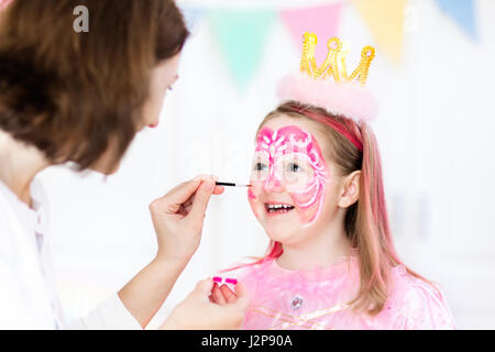 La peinture du visage de petite fille. Princesse et conte de thème d'anniversaire avec la peinture pour le visage de l'artiste et costume pour enfant d'âge préscolaire. Enfants célébrant Hallow Banque D'Images