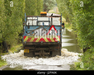 16 juillet 2012 - Les véhicules roulant dans l'inondation sur les niveaux de Somerset sur la route entre Glastonbury et Godney Banque D'Images