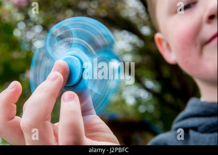 Dimanche 30 avril 2014 sur la photo : un jeune garçon utilise un fidget spinner Banque D'Images