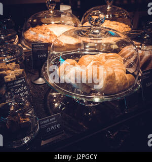 Gâteaux sous cloche de verre sur l'écran de verre de boulangerie. plein de différents morceaux de gâteaux Banque D'Images