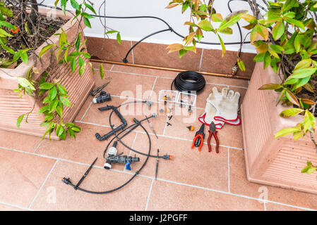 Cuivre luxueux d'irrigation au goutte à goutte, avec des tuyaux de cuivre. Système de micro-irrigation pour les plantes en pot sur une terrasse d'une maison Banque D'Images