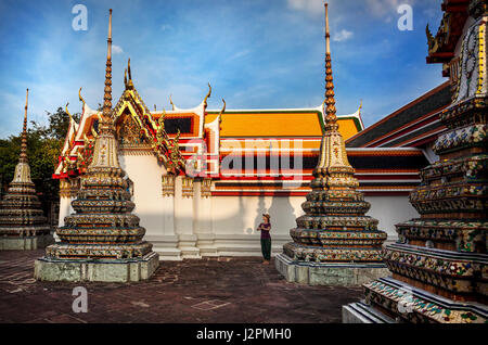 Touriste près de l'ancienne pagode Royale Stupas et au temple de Wat Pho à Bangkok au coucher du soleil Banque D'Images