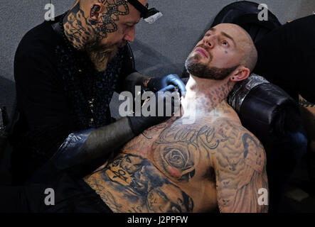 Tatoueurs montrer leurs compétences à la Big North Tattoo show 2017 au Metro Radio Arena à Newcastle. Banque D'Images