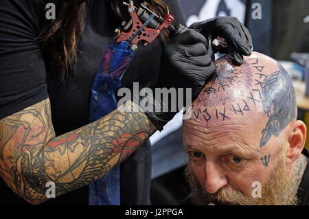 Tatoueurs montrer leurs compétences à la Big North Tattoo show 2017 au Metro Radio Arena à Newcastle. Banque D'Images