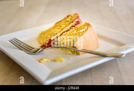 Gâteau éponge Victoria alimentaire dessert au lait partiellement mangés cuits au four doux traiter plaque fourche après-midi détente traiter l'Indulgence Banque D'Images