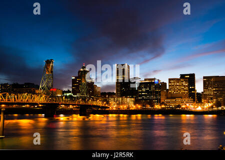 Soirée au centre du front de mer à Portland avec de couleur spectaculaires nuages sombres et reflet de la rue et de l'éclairage dans les bâtiments Banque D'Images