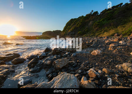 Le lever du soleil sur une plage de rochers sur la côte est de la Nouvelle-Galles du Sud, Australie Banque D'Images