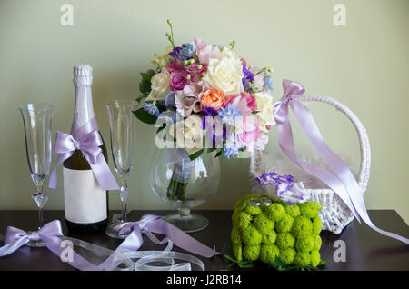 Accessoires de mariage. Les anneaux de mariage en or blanc. Bouquet de roses et de chrysanthèmes et eustoma. Champagne et verres pour de jeunes mariés Banque D'Images