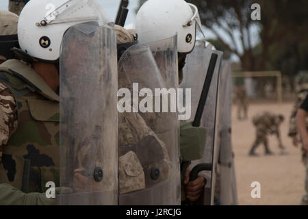 Des soldats américains avec la 805 e Compagnie de Police militaire des marines (Marine Company B, 4e Bataillon, de l'application de la Loi et Forces armées royale marocaine se tiennent prêts à se défendre contre des manifestants lors de la formation de contrôle des foules à Tifnit, Maroc, le 24 avril 2017, lors de l'exercice Lion d'Afrique. Lion d'Afrique est un exercice programmé chaque année, combiné exercice multilatéral visant à améliorer l'interopérabilité et la compréhension mutuelle de chaque nation de tactiques, techniques et procédures.(Photo prise par le sergent de l'armée américaine. Christopher Osburn) Banque D'Images