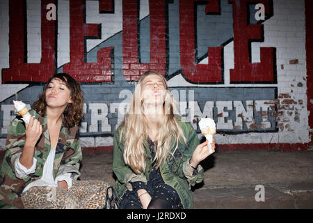 Deux jeunes femmes eating ice cream Banque D'Images