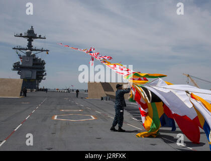 NORFOLK, Virginie (27 avril 2017) -- 1ère classe Quartier-maître José Triana, affecté à l'unité Pre-Commissioning Gerald R. Ford (CVN 78), s'attache à une ligne de drapeaux du signal. Ford's 'top' sur les lignes sont testés par le poids de la navigation du navire. (U.S. Photo par marine Spécialiste de la communication de masse 3 classe Elizabeth A. Thompson) Banque D'Images