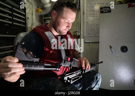170427-N-UM082-005 U.S. 5ÈME ZONE DES OPÉRATIONS DE LA FLOTTE (27 avril 2017) Gunner's Mate 2e classe Noël Cody nettoie et inspecte un fusil M4 dans l'armoirie de l'assaut amphibie USS Bataan (DG 5). Le navire et son groupe sont déployés dans la zone 5e flotte américaine des opérations à l'appui d'opérations de sécurité maritime visant à rassurer les alliés et les partenaires, et de préserver la liberté de navigation et la libre circulation du commerce dans la région. (U.S. Photo par marine Spécialiste de la communication de masse 3e classe Raymond Minami/libérés) Banque D'Images