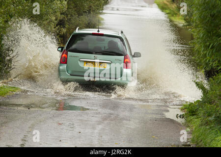 16 juillet 2012 - Les véhicules roulant dans l'inondation sur les niveaux de Somerset sur la route entre Glastonbury et Godney Banque D'Images