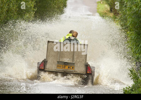 16 juillet 2012 - Les véhicules roulant dans l'inondation sur les niveaux de Somerset sur la route entre Glastonbury et Godney Banque D'Images