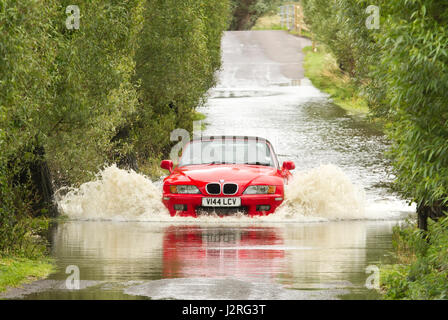 16 juillet 2012 - Les véhicules roulant dans l'inondation sur les niveaux de Somerset sur la route entre Glastonbury et Godney Banque D'Images