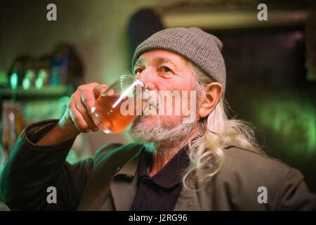 Un vieil homme de boire un verre de vin. Banque D'Images