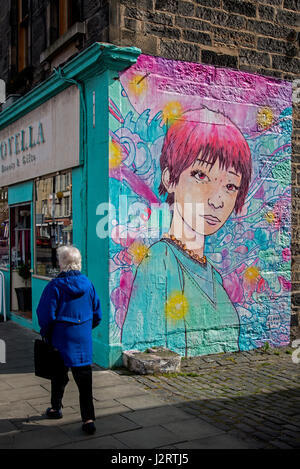 Une femme marche par un morceau de street art sur Leith Walk, Édimbourg, Écosse, Royaume-Uni. Banque D'Images