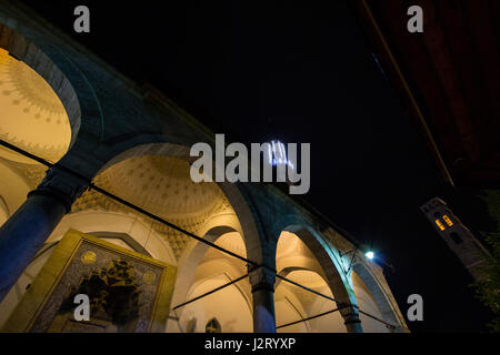 La mosquée Gazi Husrev Begova à Sarajevo dans la soirée. Le bazar de Sarajevo tour de l'horloge peut être vu dans l'arrière-plan. La mosquée est l'un des principaux pays Banque D'Images