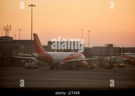 Lever du soleil à l'aéroport de Manchester un vol Easyjet à sa porte. Banque D'Images